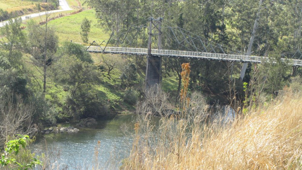 A Bridge Over a River Surrounded by Tall Grass and Trees — PH Power in Wauchope, NSW
