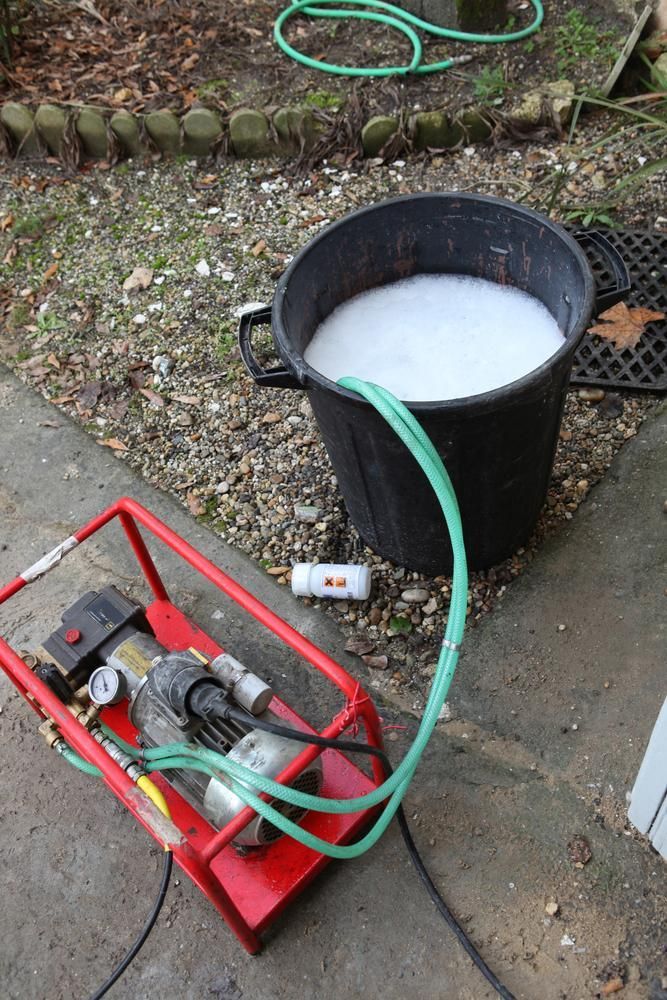 A Black Bucket Filled with White Liquid Is Connected to A Green Hose — Natraspray Lismore in Nimbin, NSW