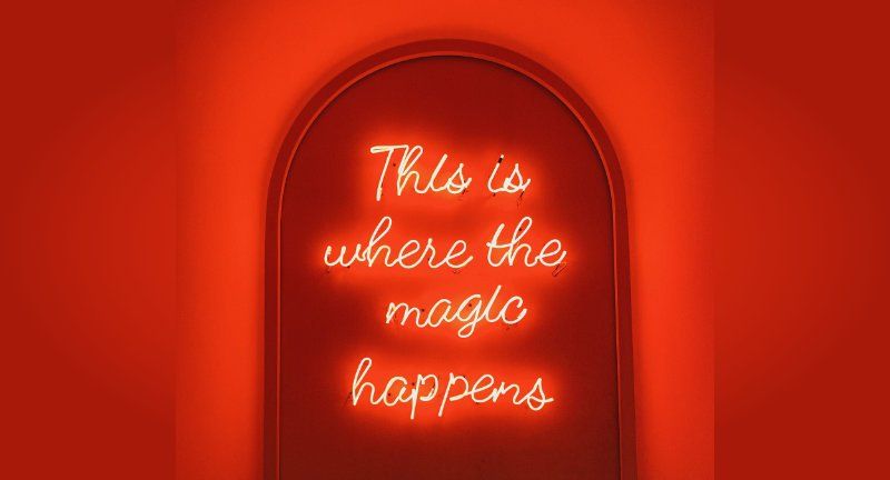This is where the magic happens neon sign on door