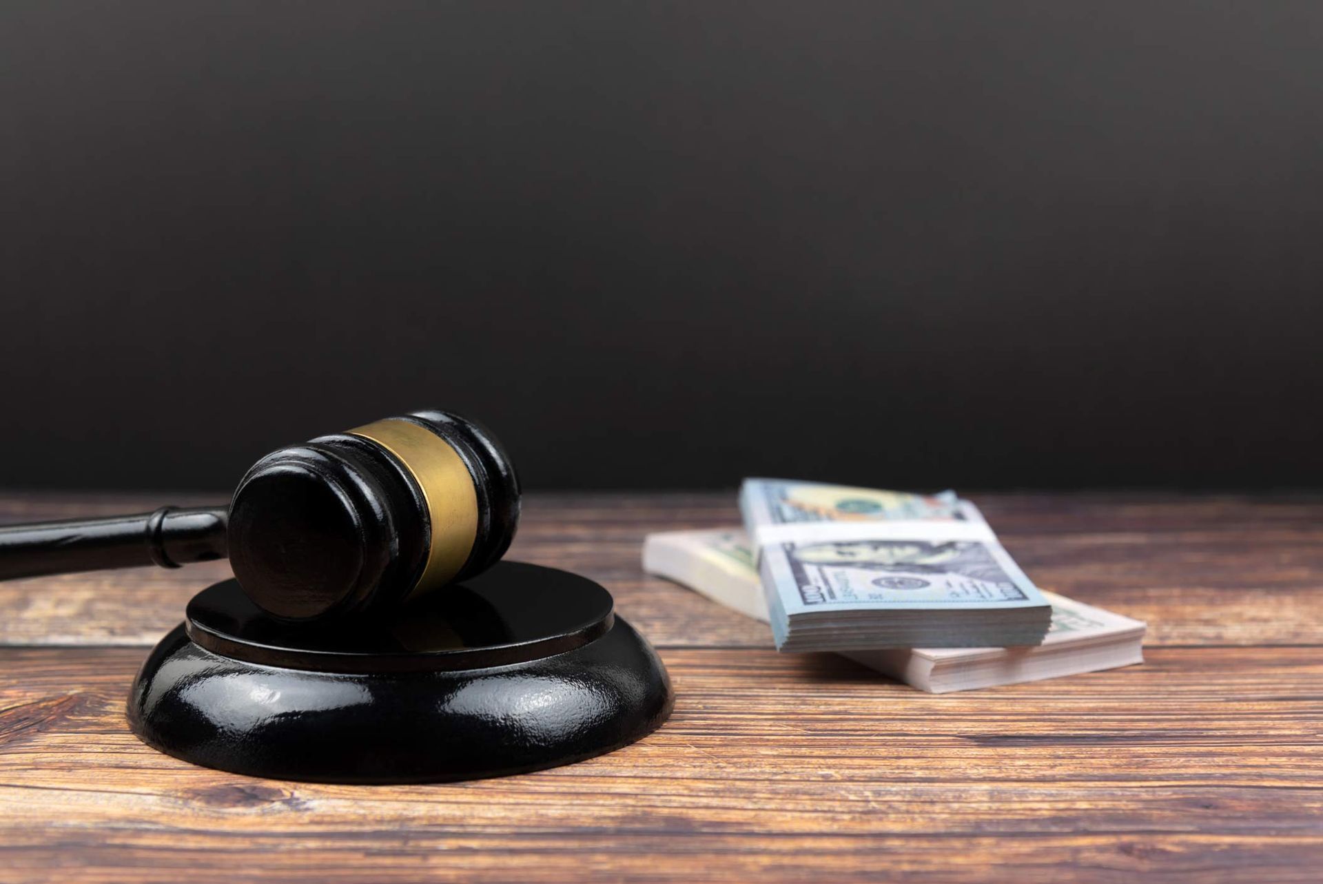 Gavel on table with cash stack in background. Gavel on table with cash stack in background.