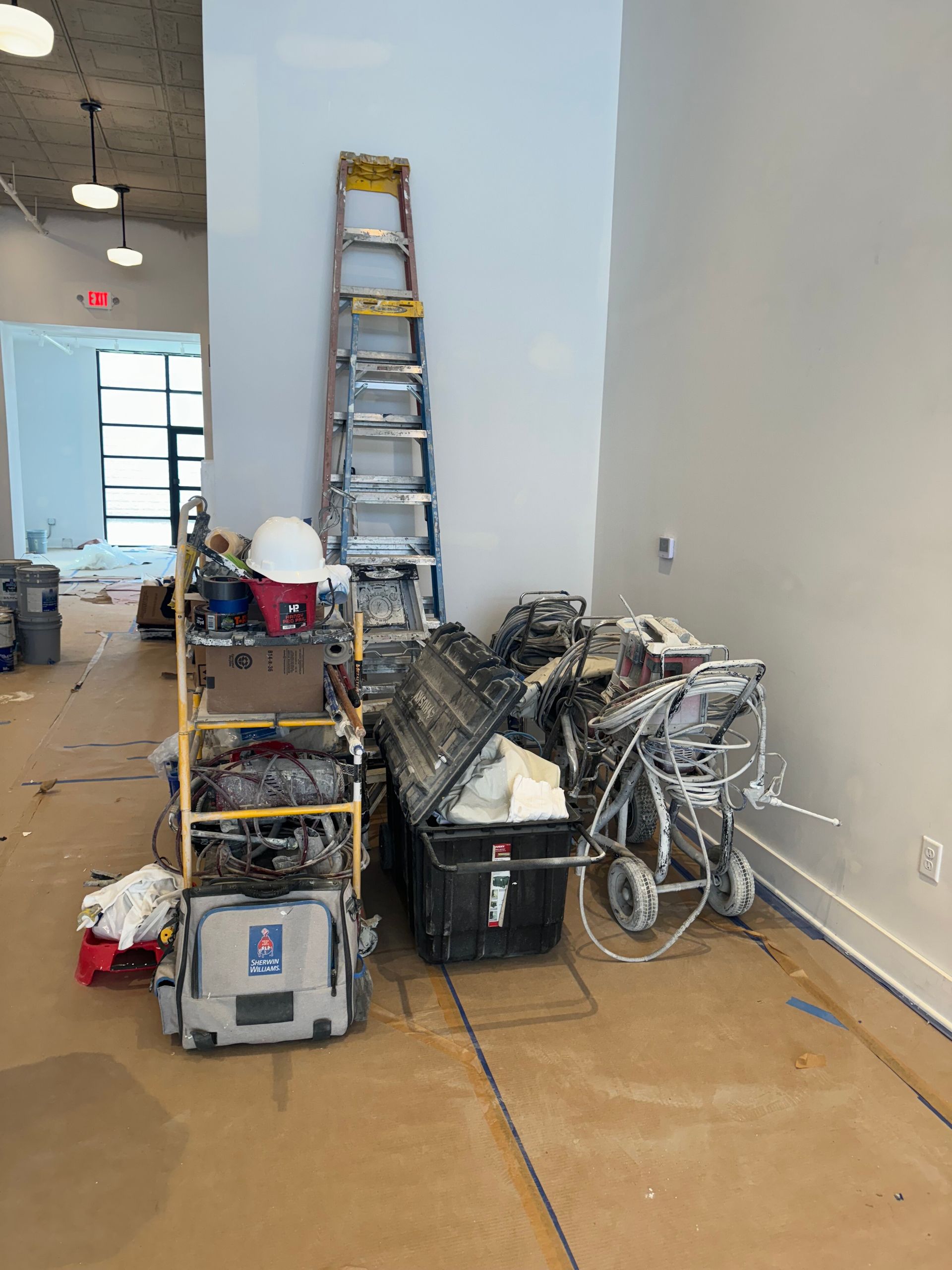 A room with a lot of tools and a ladder on the floor.