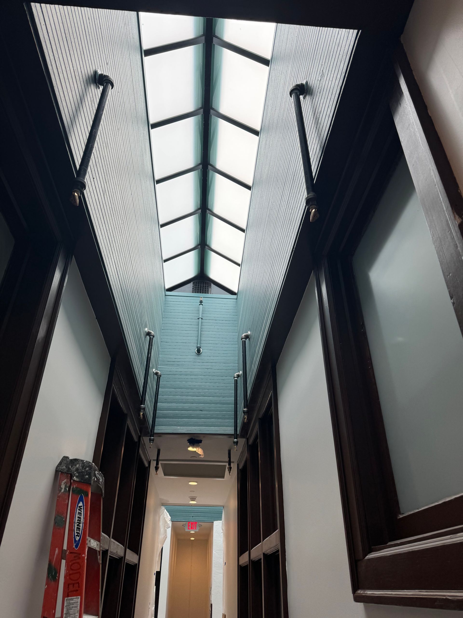 A ladder is leaning against a wall in a hallway