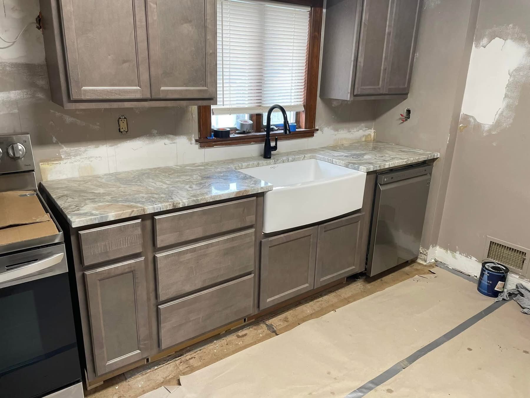 A kitchen with a sink , stove , and dishwasher.