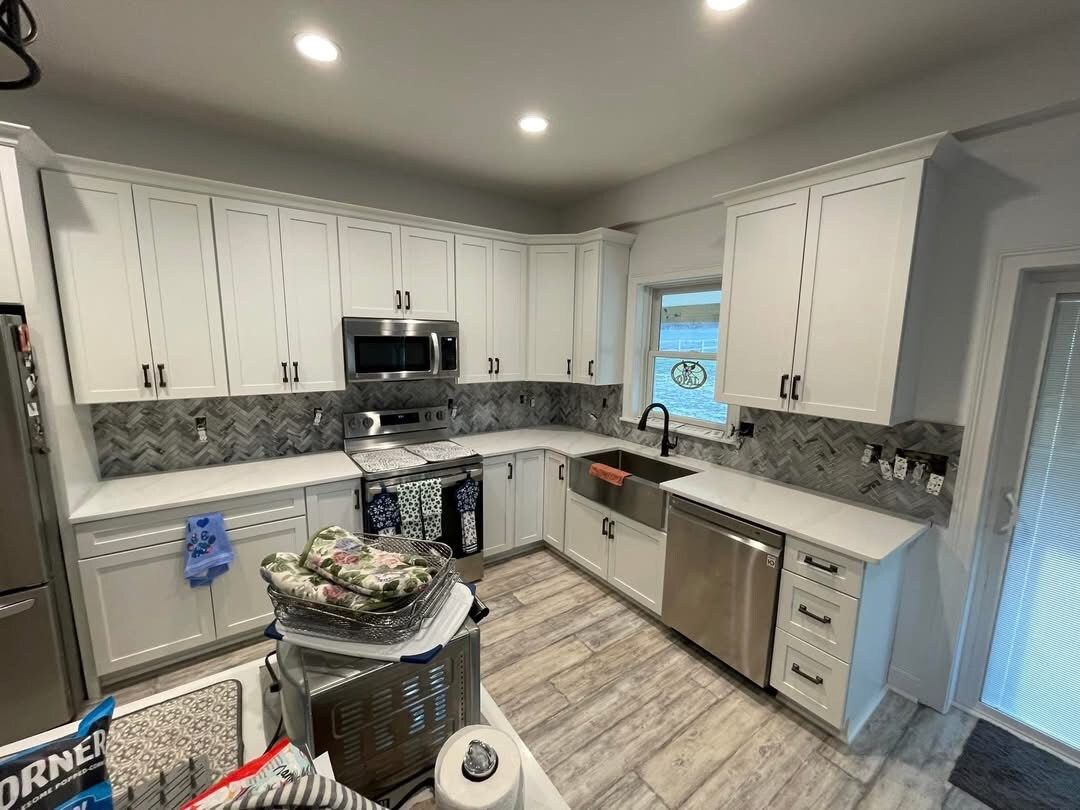 A kitchen with white cabinets and stainless steel appliances.