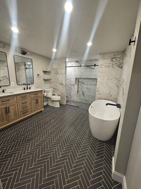 A bathroom with a bathtub , toilet , sink and mirrors.