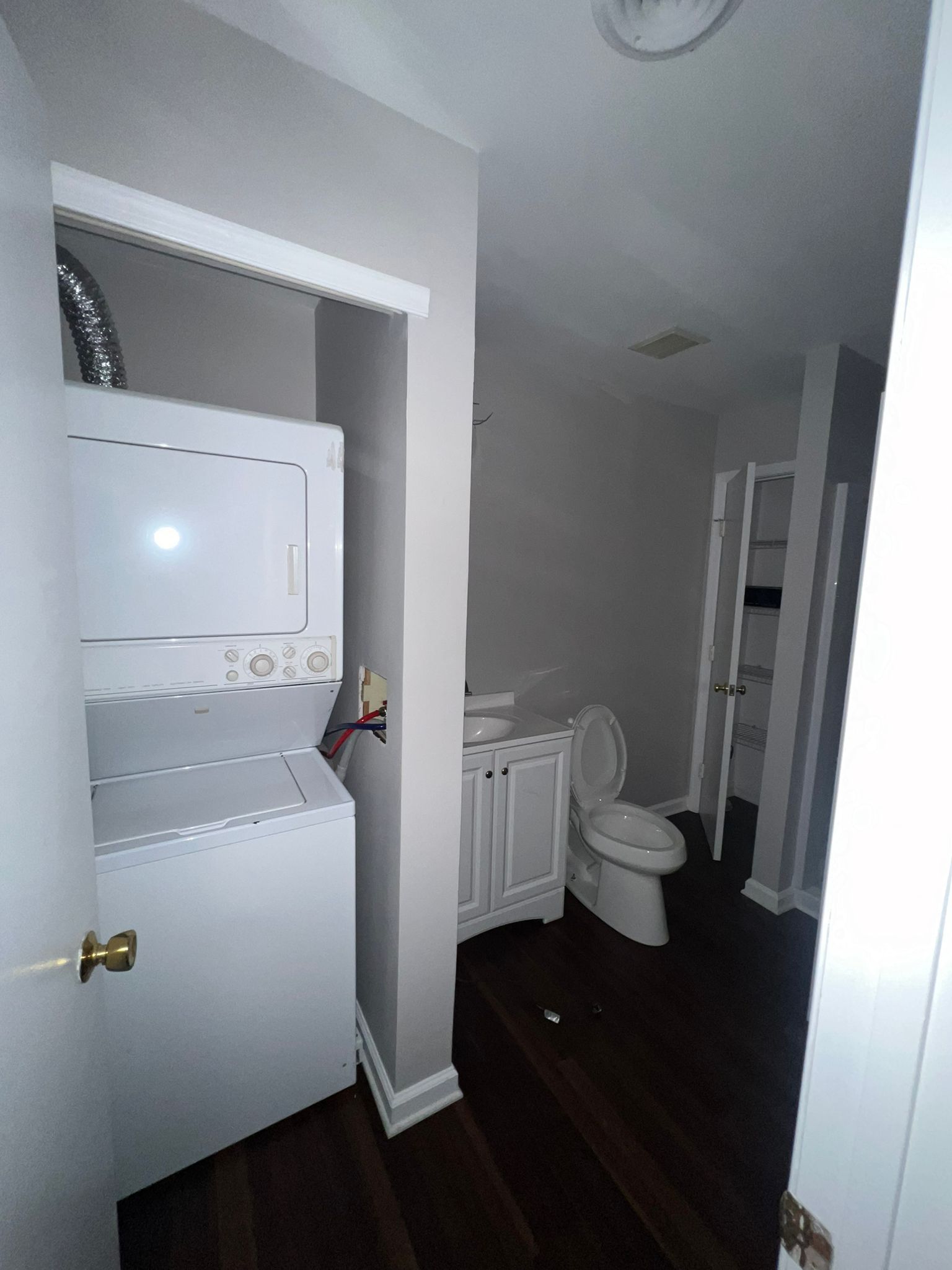 A bathroom with a washer and dryer and a toilet.