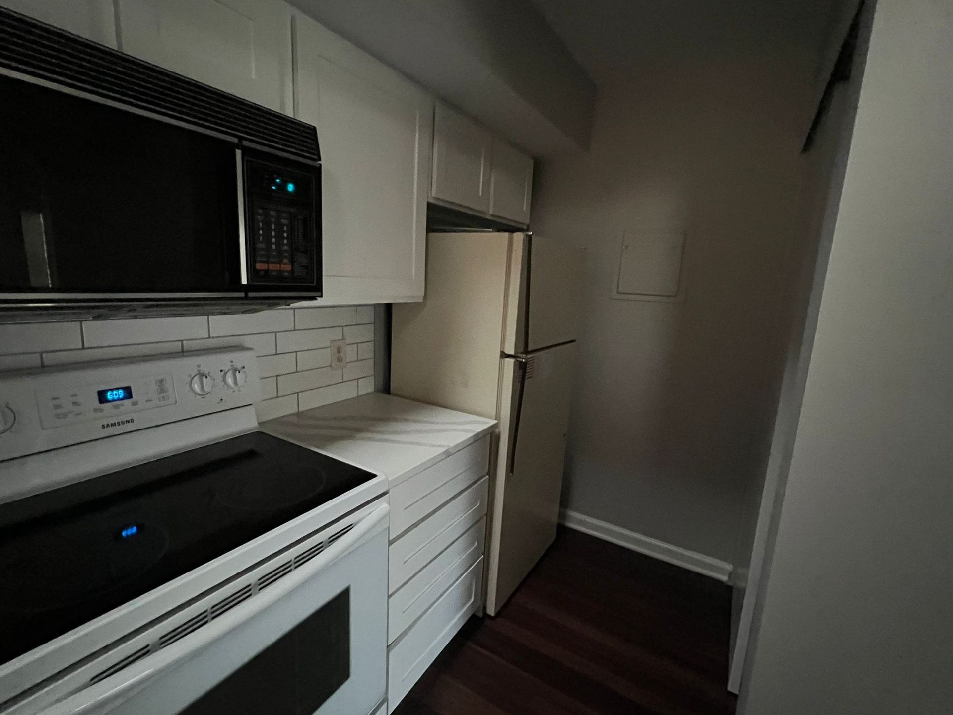 A kitchen with a refrigerator , stove , microwave , and cabinets.