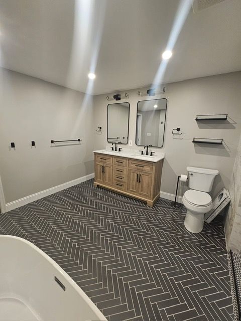 A bathroom with two sinks , a toilet , and a bathtub.
