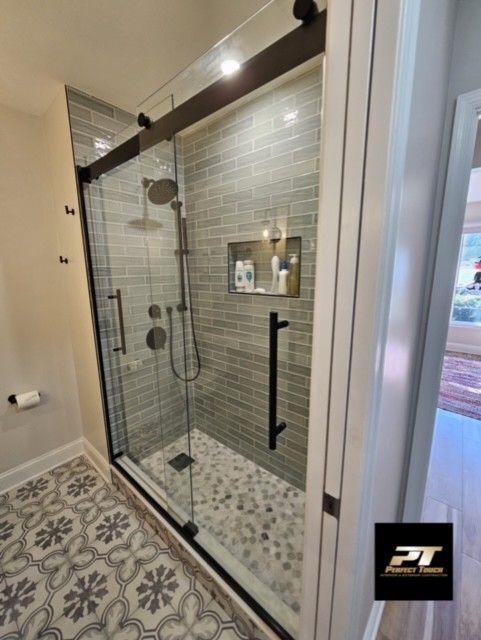 A bathroom with a sliding glass shower door