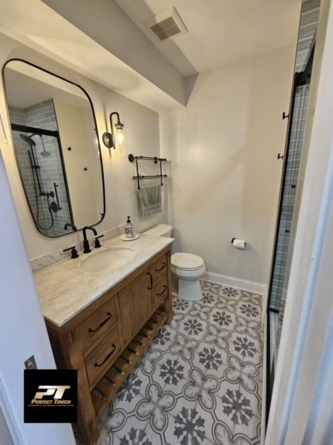 A bathroom with a toilet a sink and a mirror