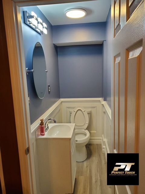 A bathroom with a toilet a sink and a mirror