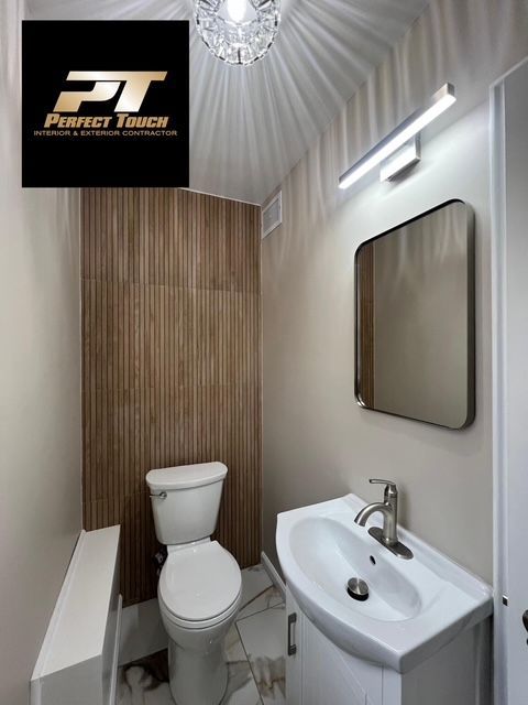 A bathroom with a toilet and sink and a perfect touch logo