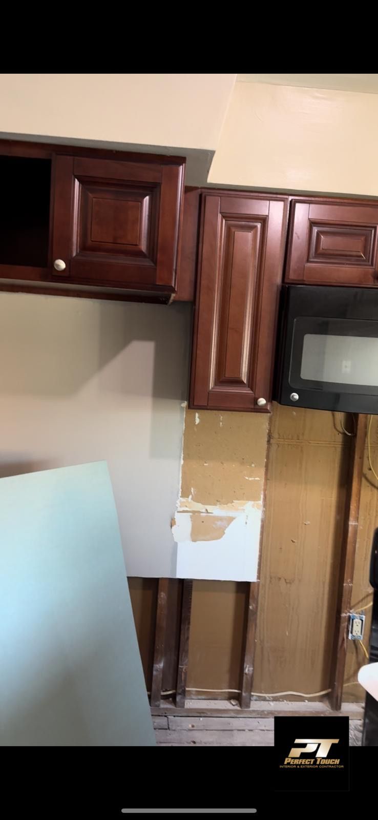 A kitchen with wooden cabinets and a microwave.