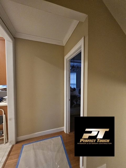 A hallway with a perfect touch logo on the wall