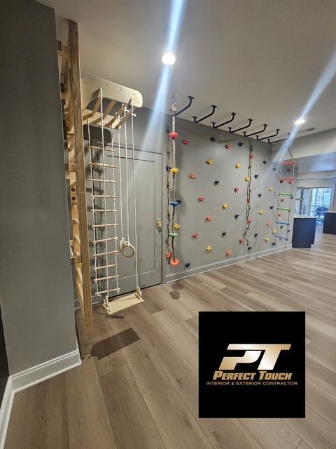 A room with a climbing wall and a perfect touch logo