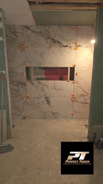 A room with a marble wall and a window in it.