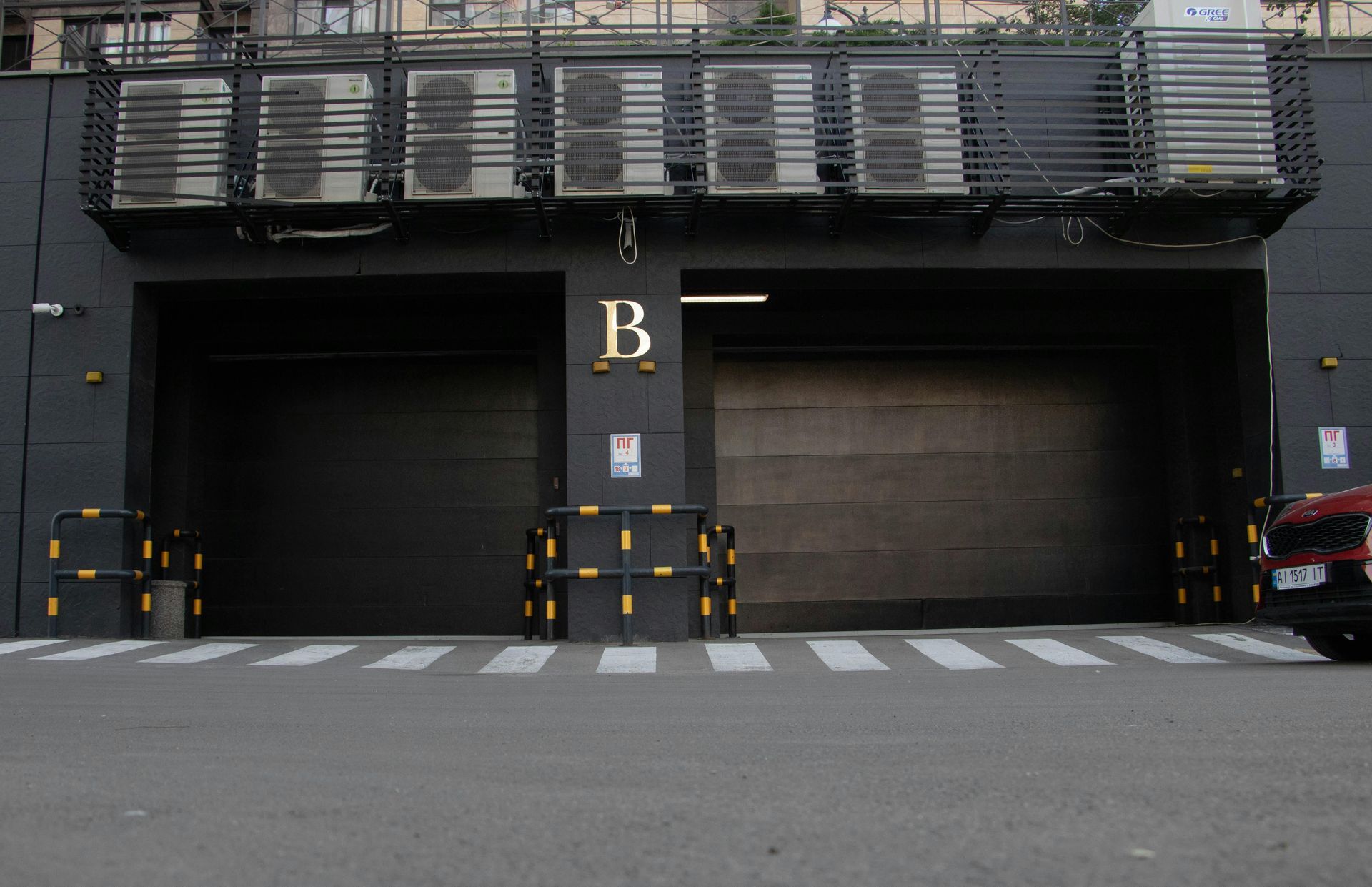 Dark gray building entrance with two closed garage doors, marked
