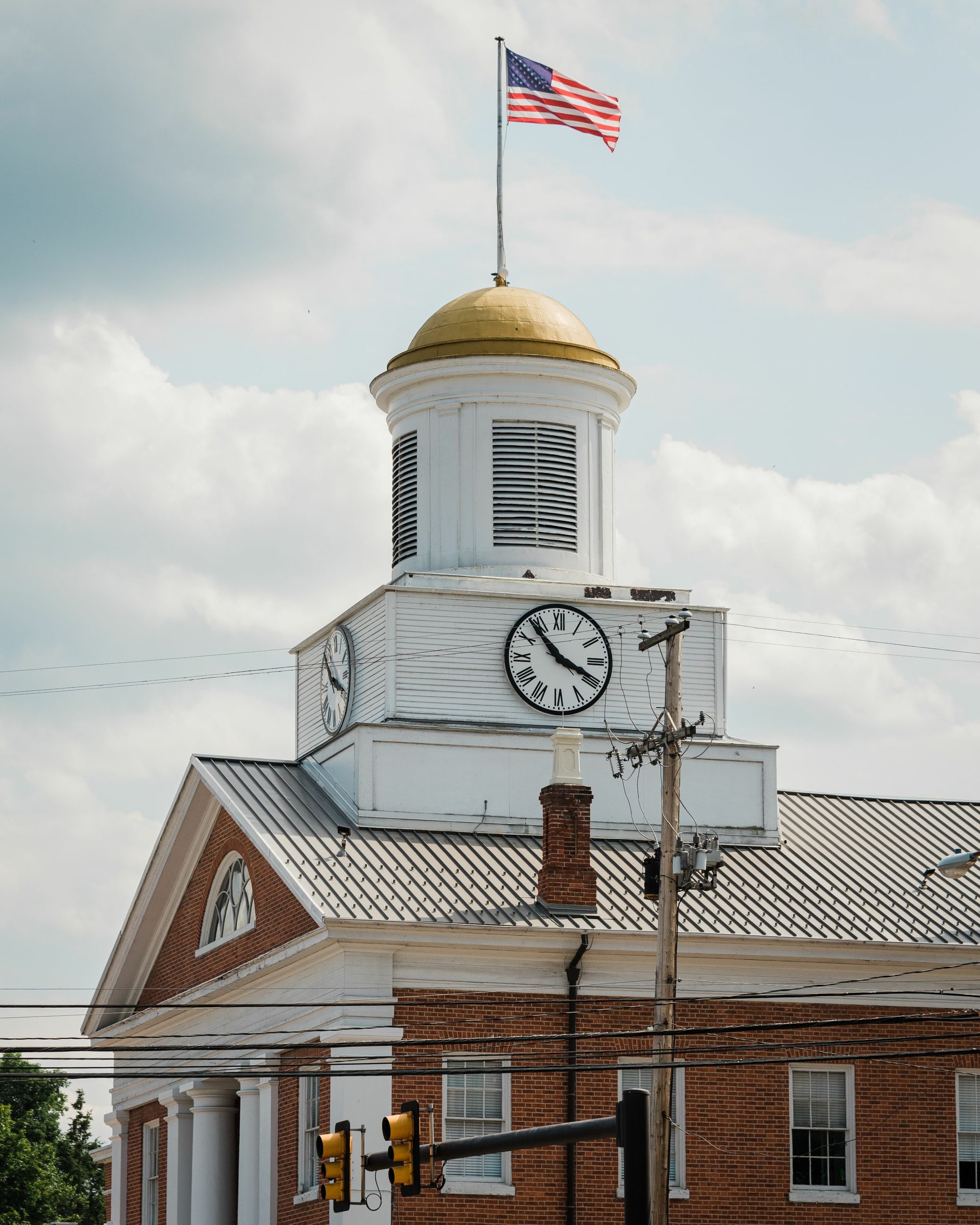 A clock tower with an american flag on top of it