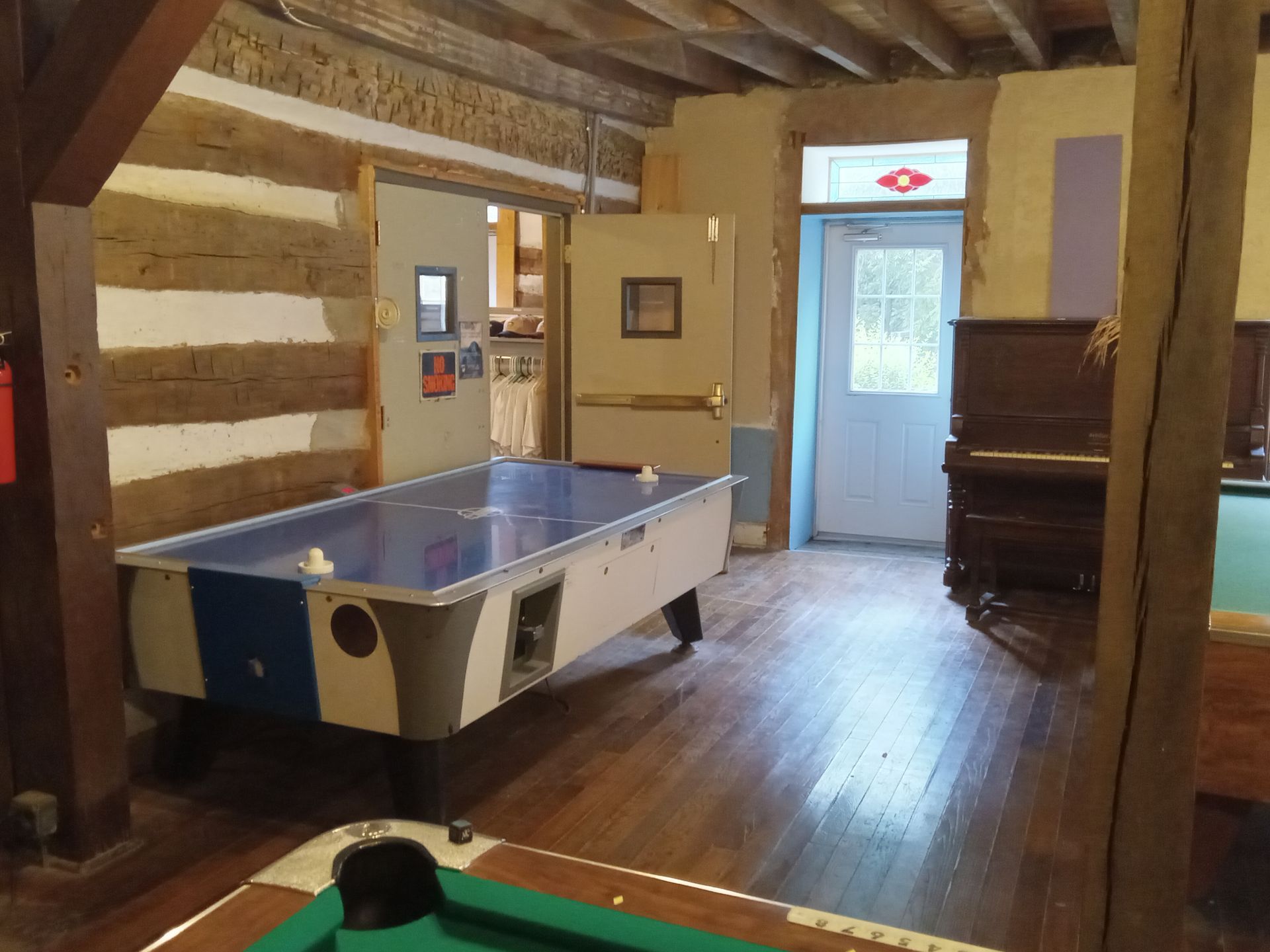 A pool table and air hockey table in a room