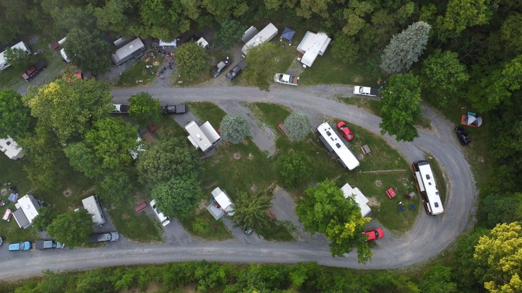 An aerial view of a campground filled with rvs and tents.