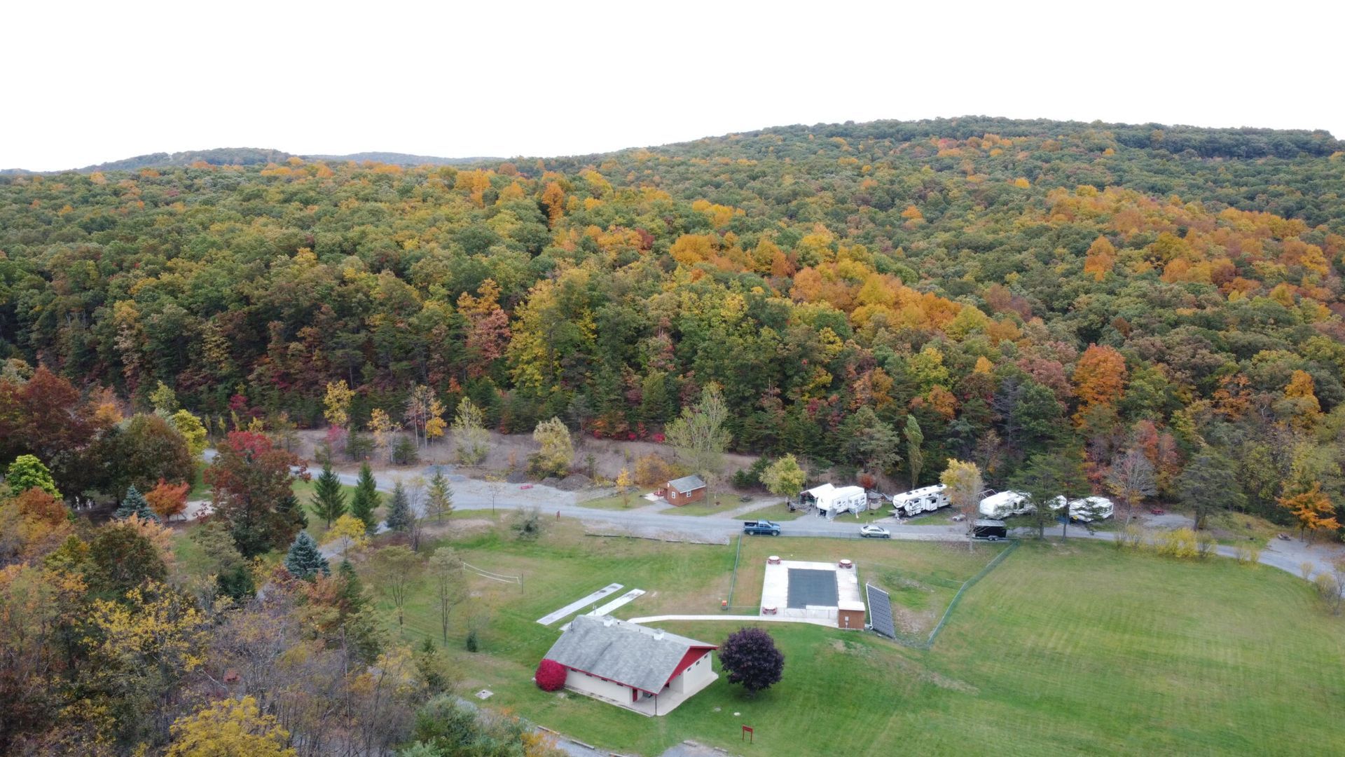 An aerial view of a farm in the middle of a forest.