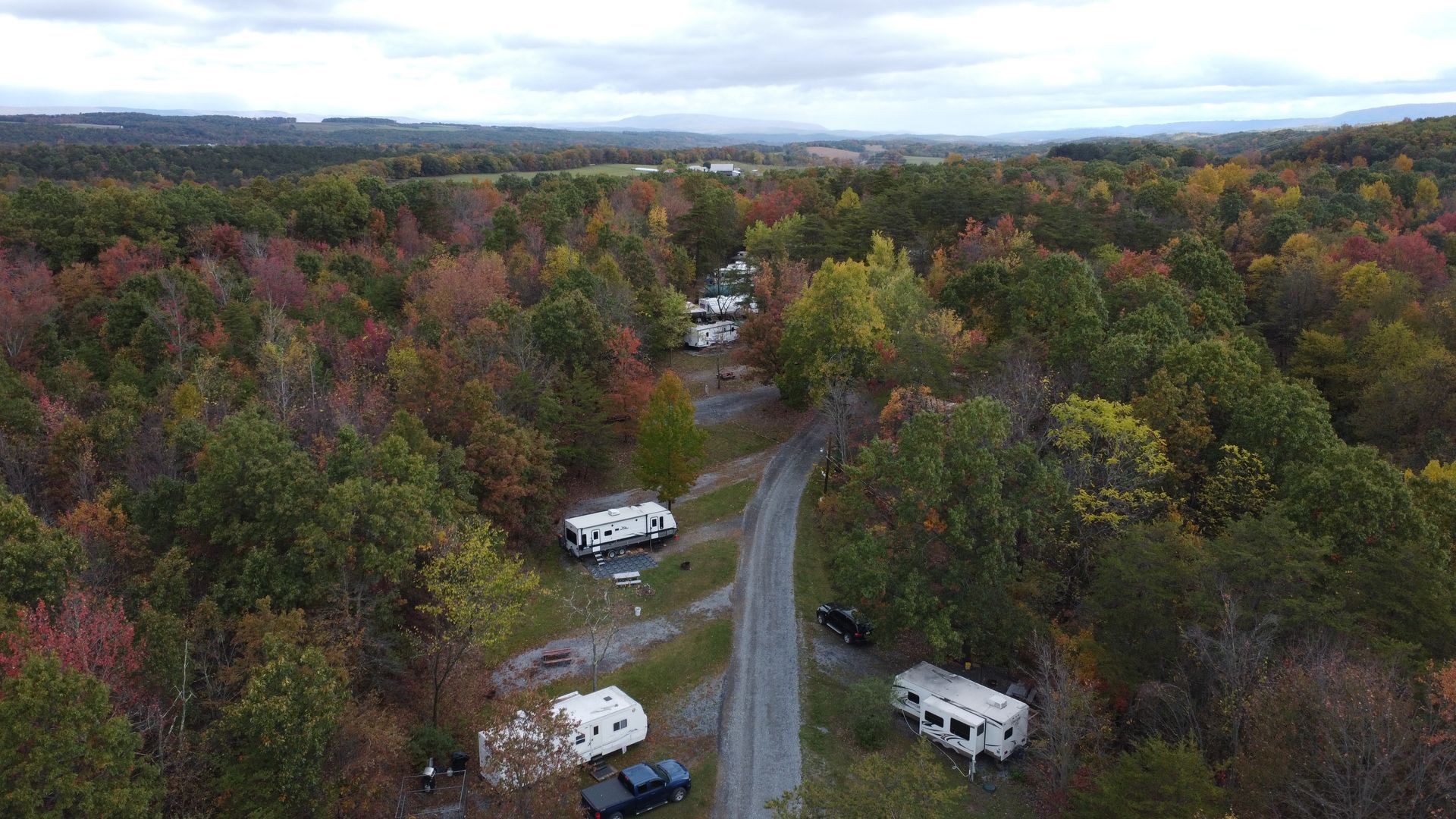 An aerial view of a rv park in the middle of a forest.