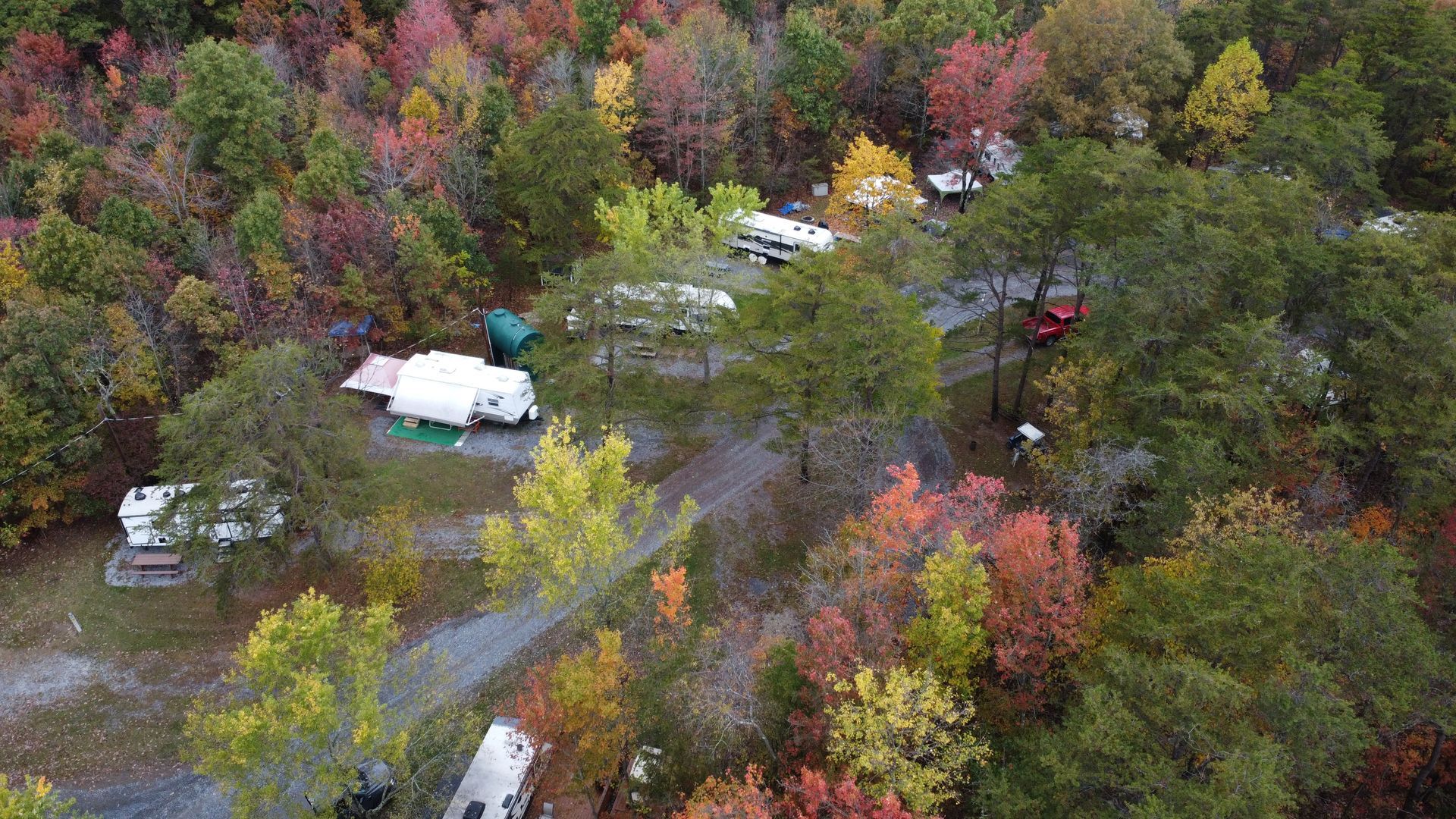 An aerial view of a campground surrounded by trees in the woods.