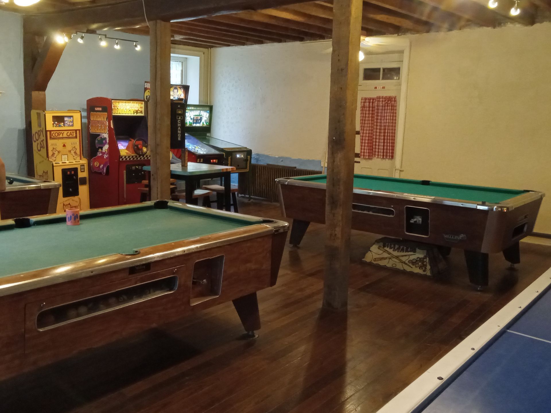 A room with pool tables and arcade games in it