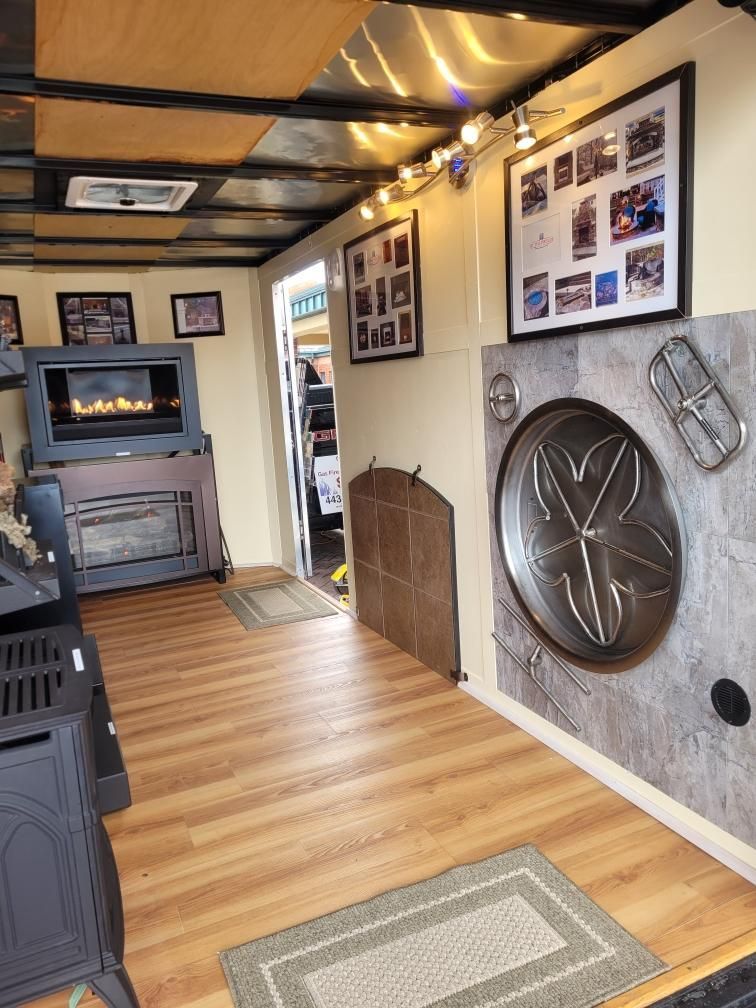 A living room with a fireplace and pictures on the wall — Glen Burnie, MD — McAllister Plumbing Inc.