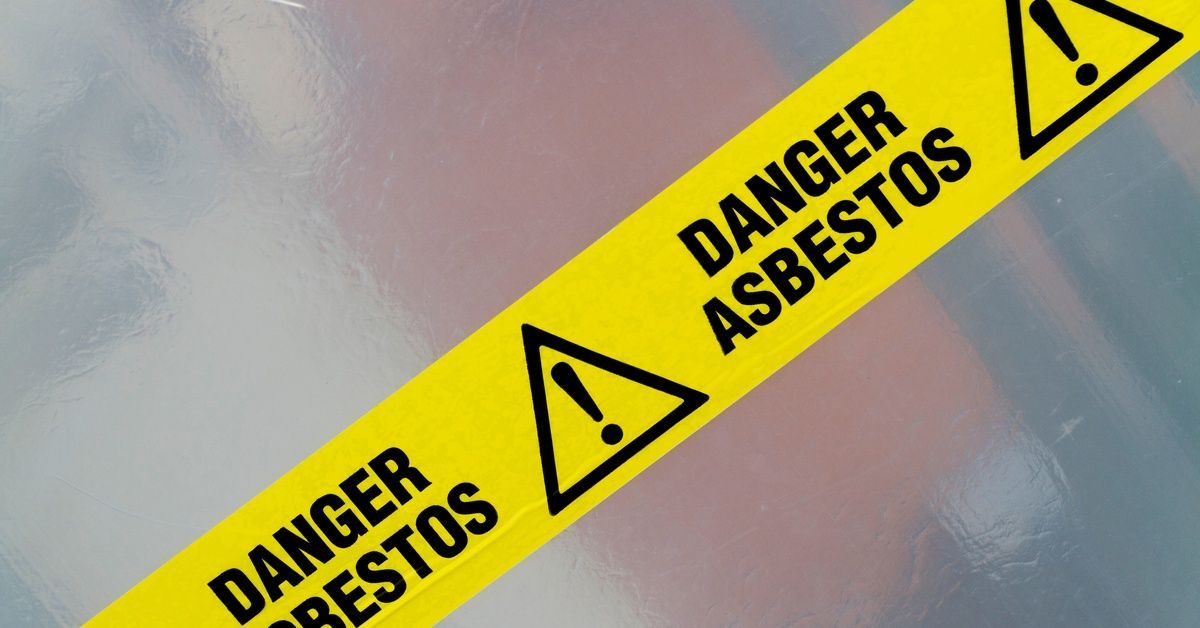 A piece of yellow caution tape stretches across the frame diagonally. It reads,