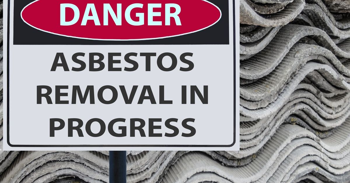 A sign reads 'DANGER: ASBESTOS REMOVAL IN PROGRESS' against a background of asbestos sheets.