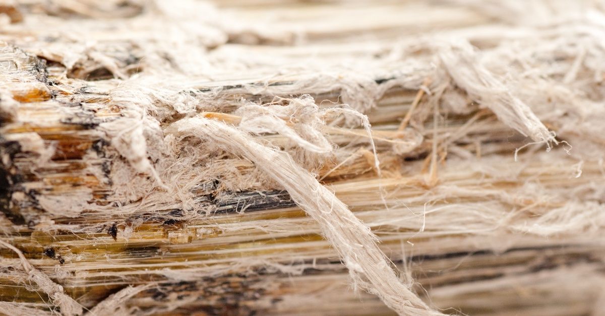 A close-up of fibrous, layered insulation material with frayed strands and a textured surface.