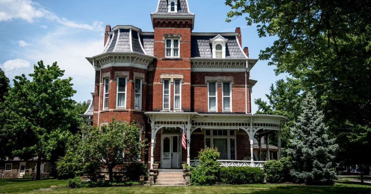 A Victorian-style home with detailed architecture and colorful facades on a street.
