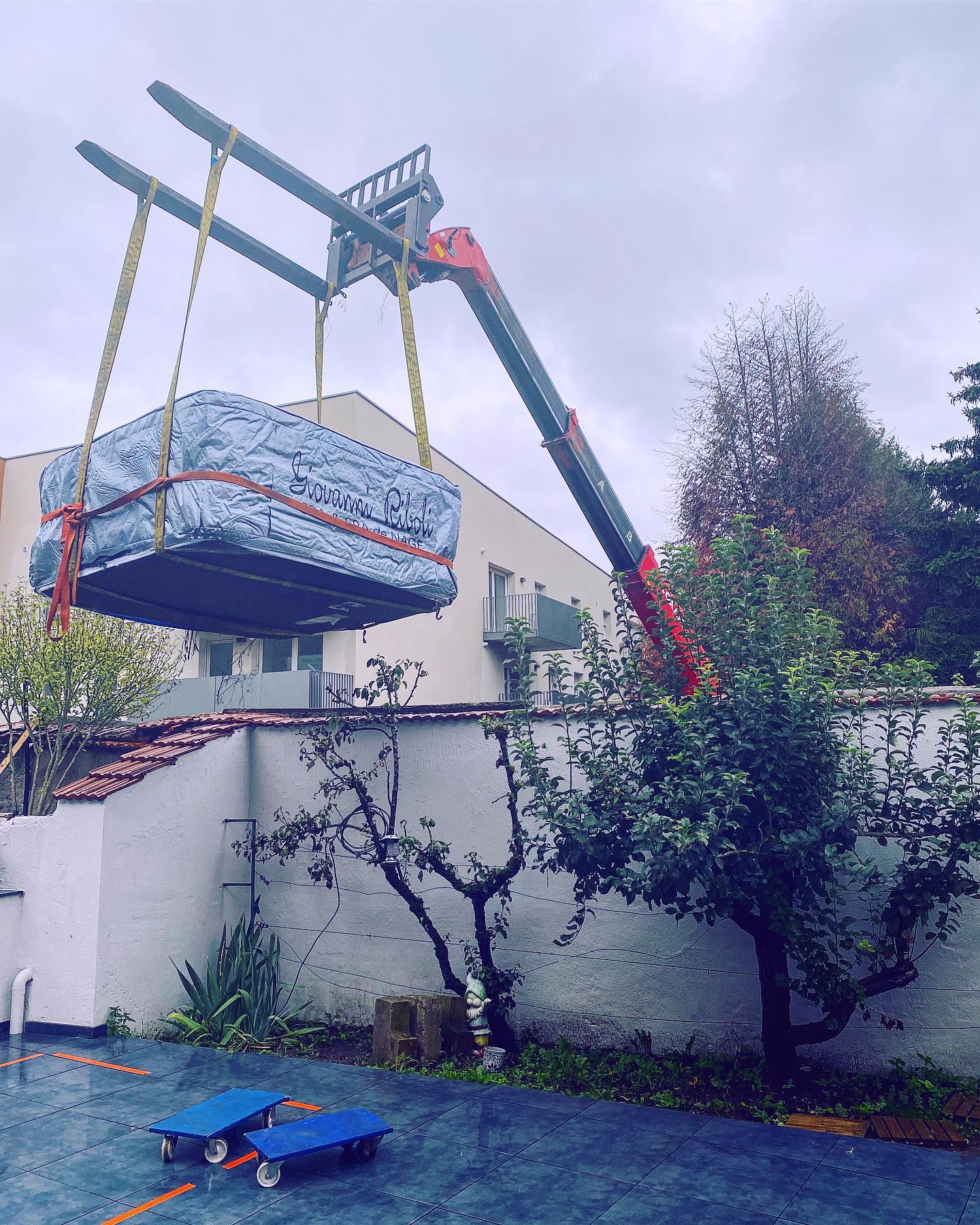 Un gros meuble est soulevé par une grue