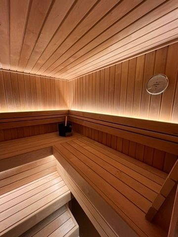 Un sauna en bois avec des lumières sur les murs et le plafond.
