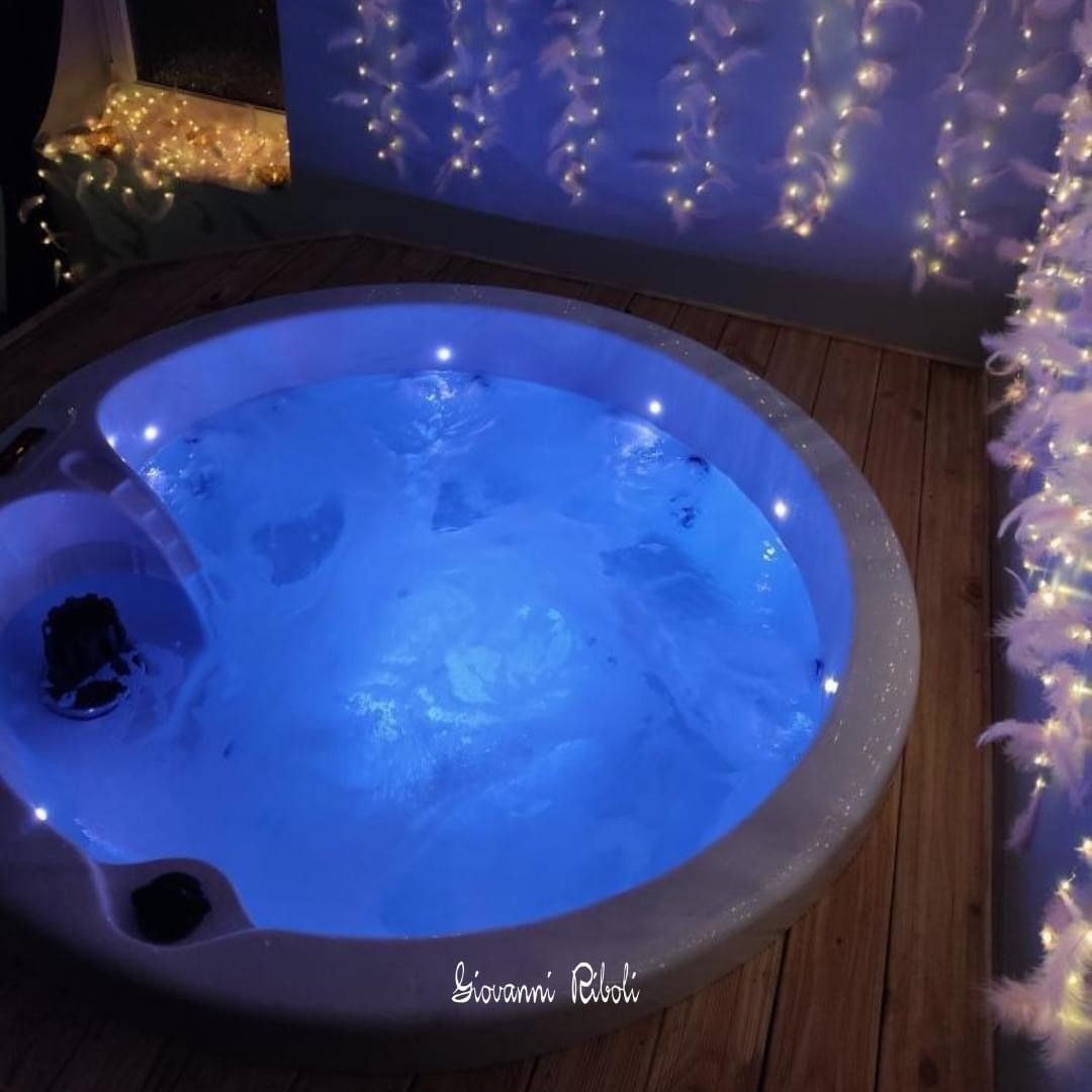 Un jacuzzi est éclairé par des lumières bleues et le mot bazowi est écrit au fond