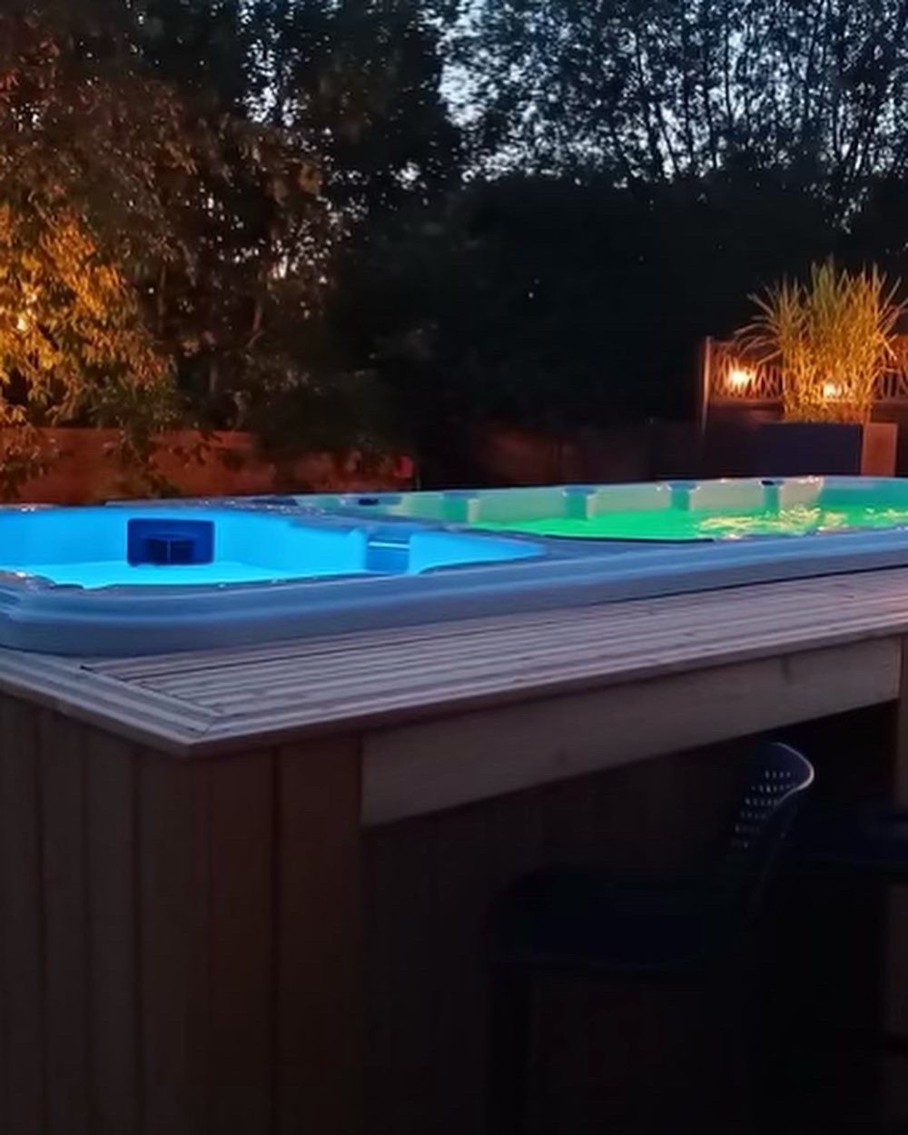 Un bain à remous est éclairé la nuit dans une cour arrière.