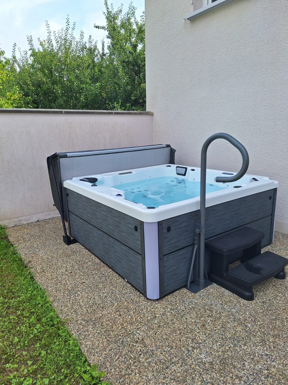 Un bain à remous est installé dans l'arrière-cour d'une maison.