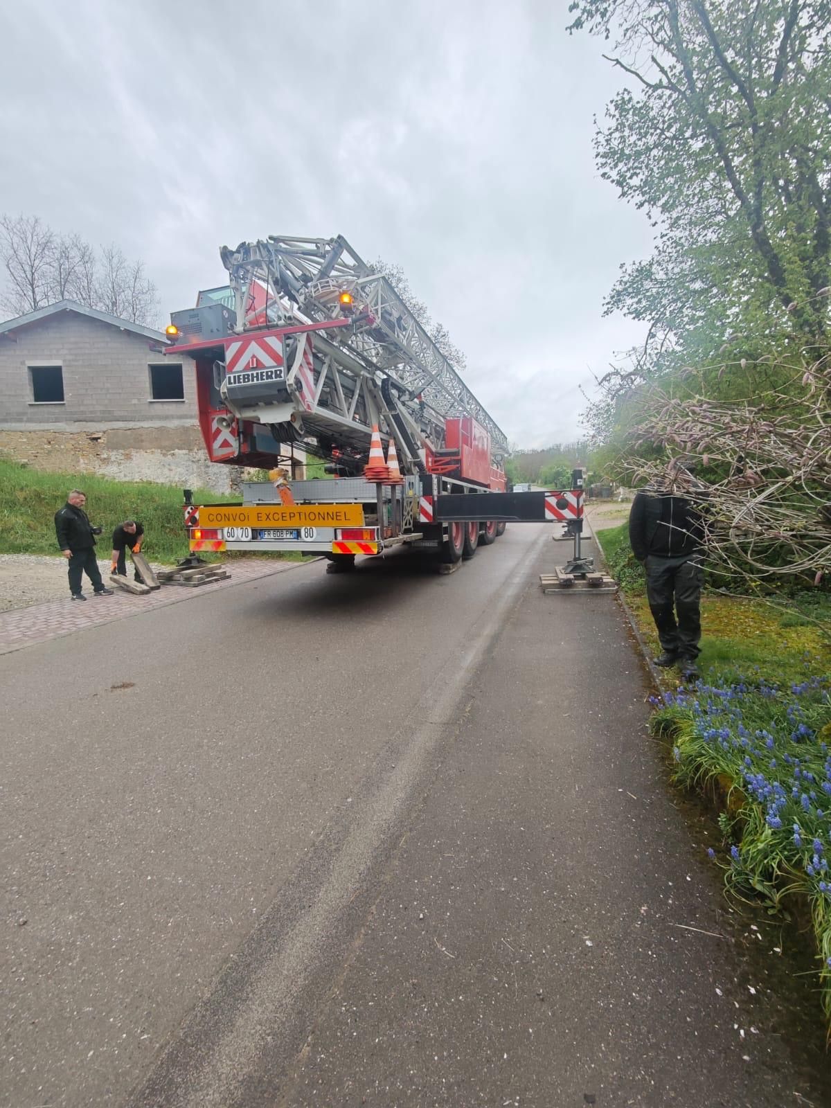 Un camion avec une échelle à l'arrière roule sur une route.