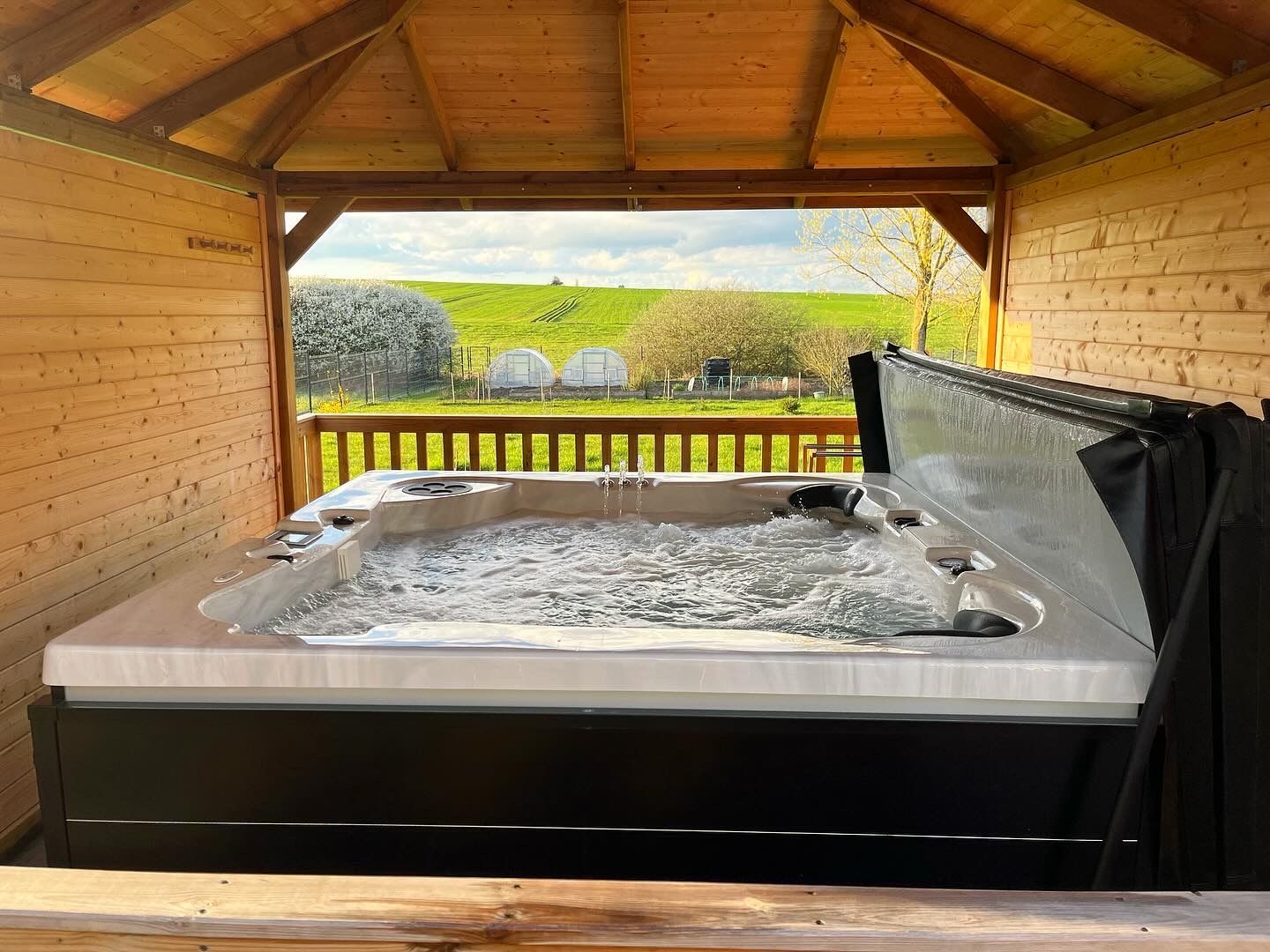 Un bain à remous est installé à l'intérieur d'un gazebo en bois.