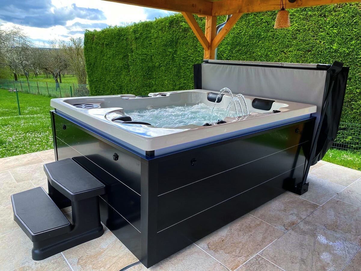 Un bain à remous est installé sur une terrasse sous un gazebo.