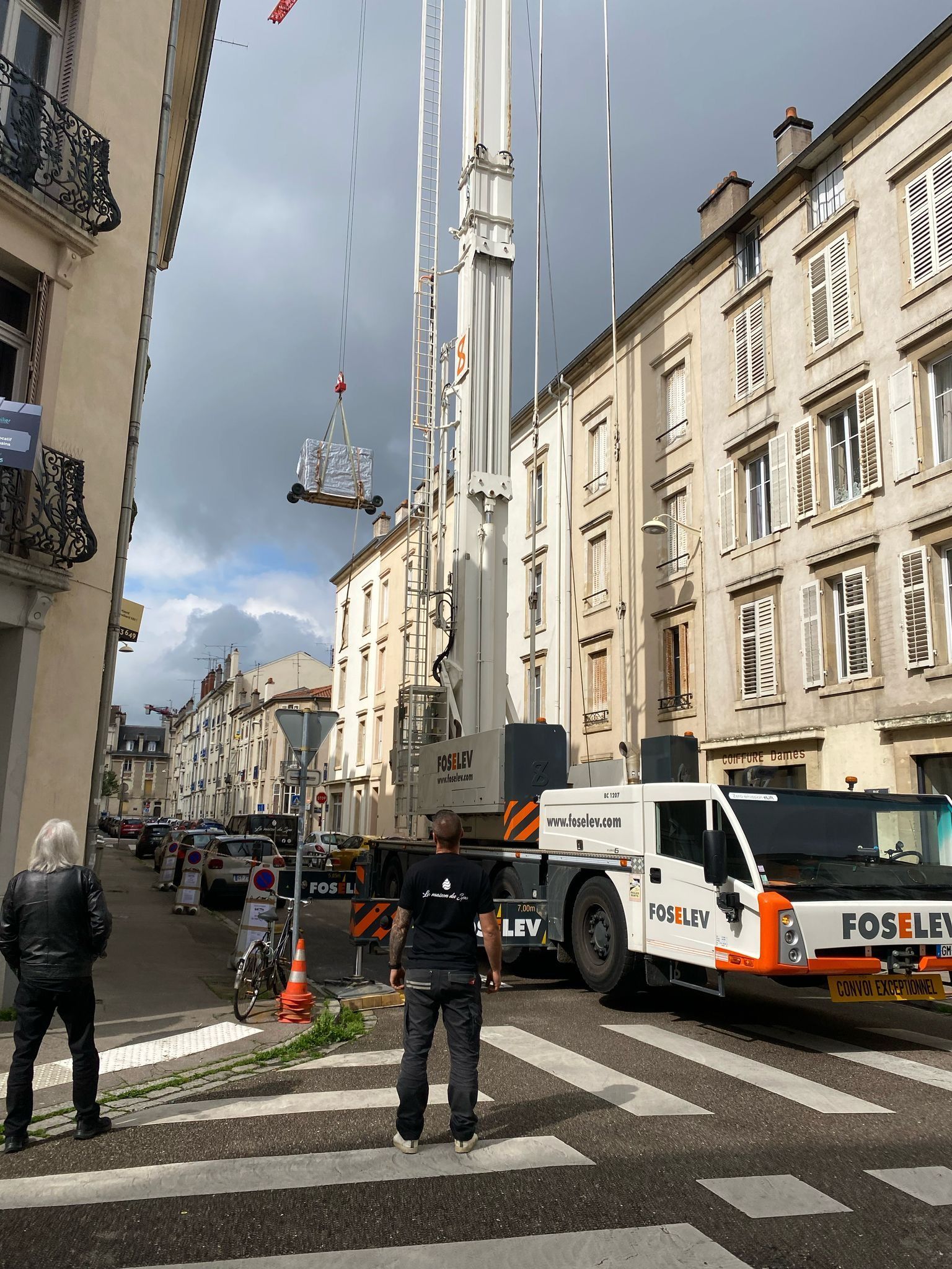 Une grue est soulevée dans les airs dans une rue de la ville.