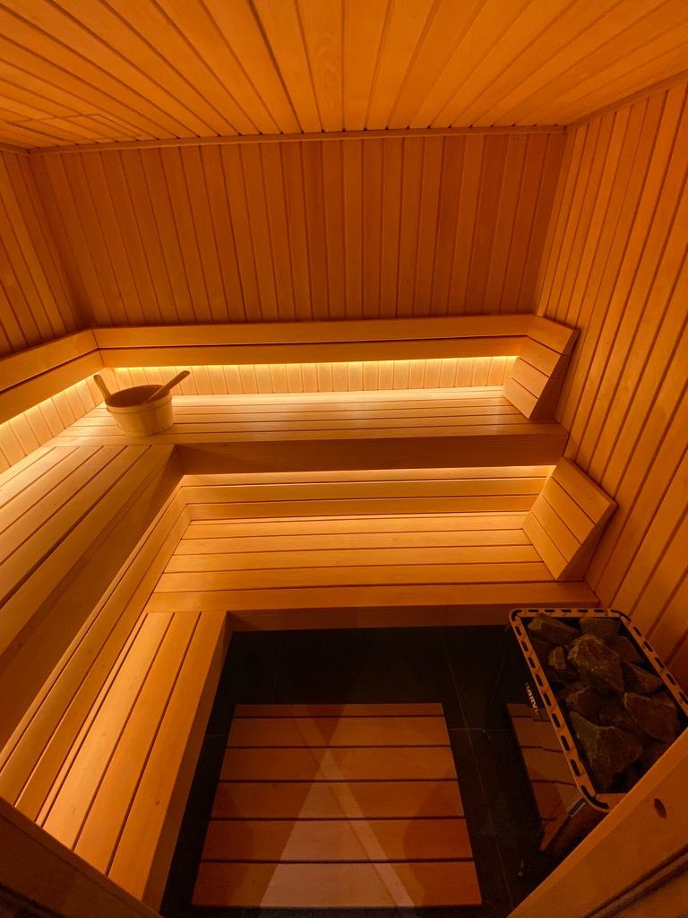 L'intérieur d'un sauna en bois avec un seau sur le banc.