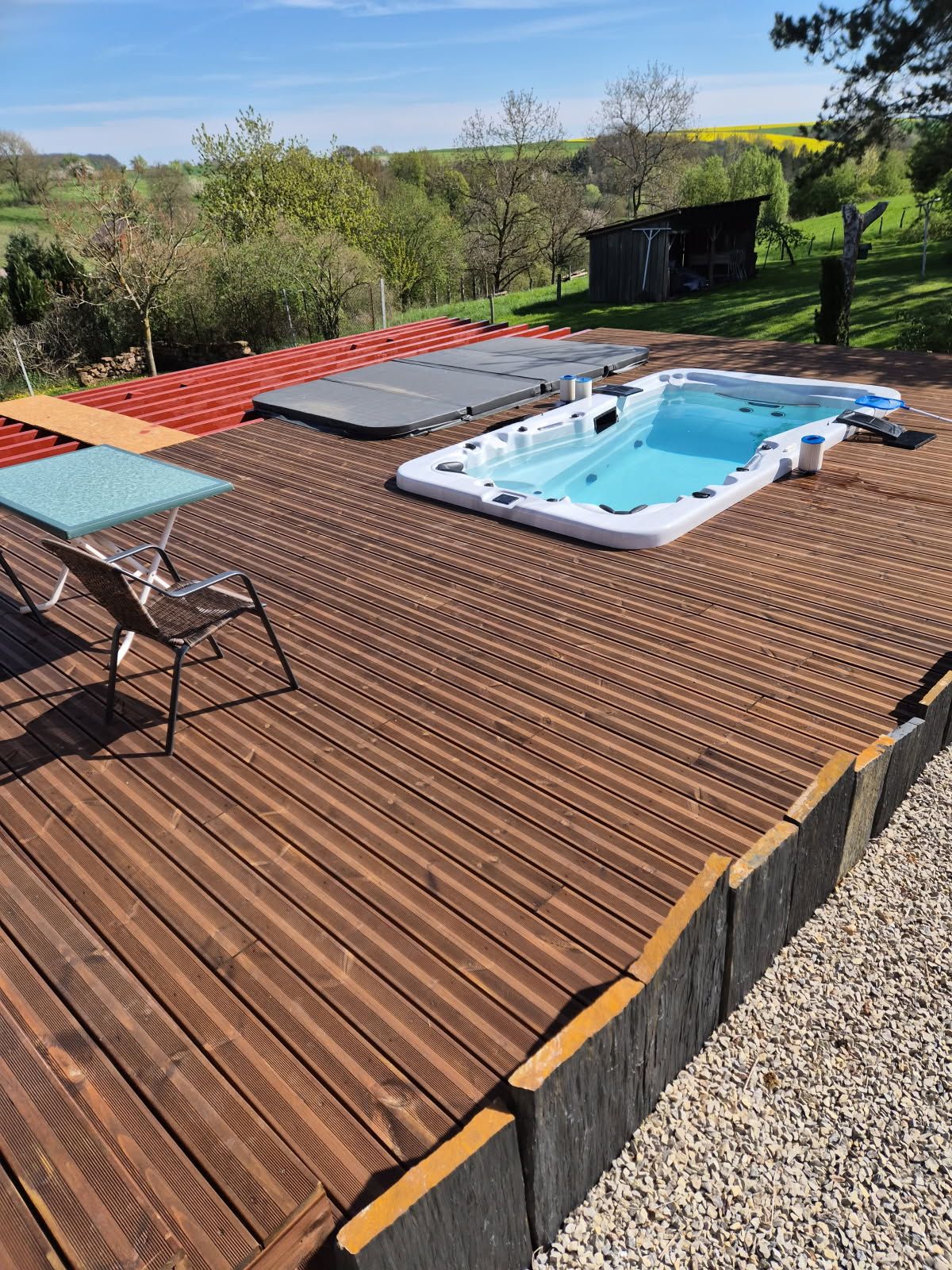 Une grande piscine est située sur une terrasse en bois.