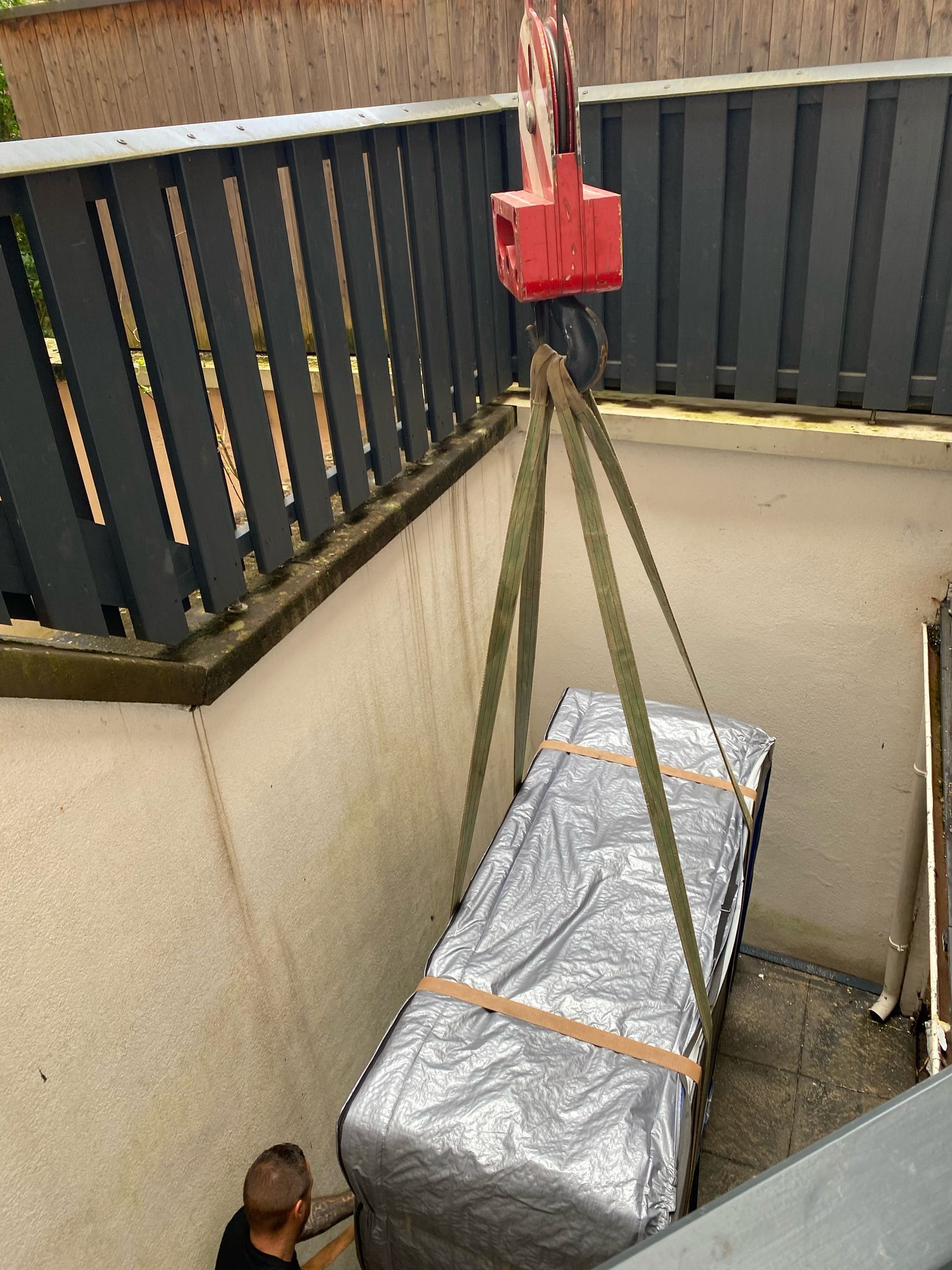 Un homme soulève un gros meuble avec une grue.