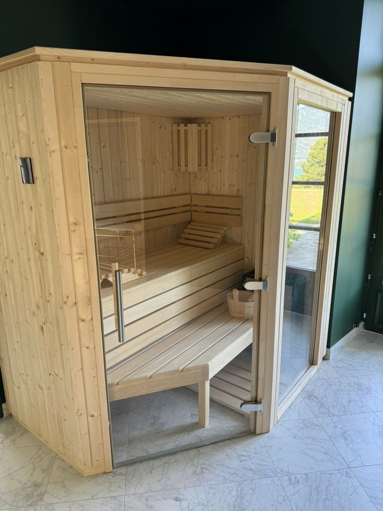 Un sauna en bois avec une porte vitrée et un banc