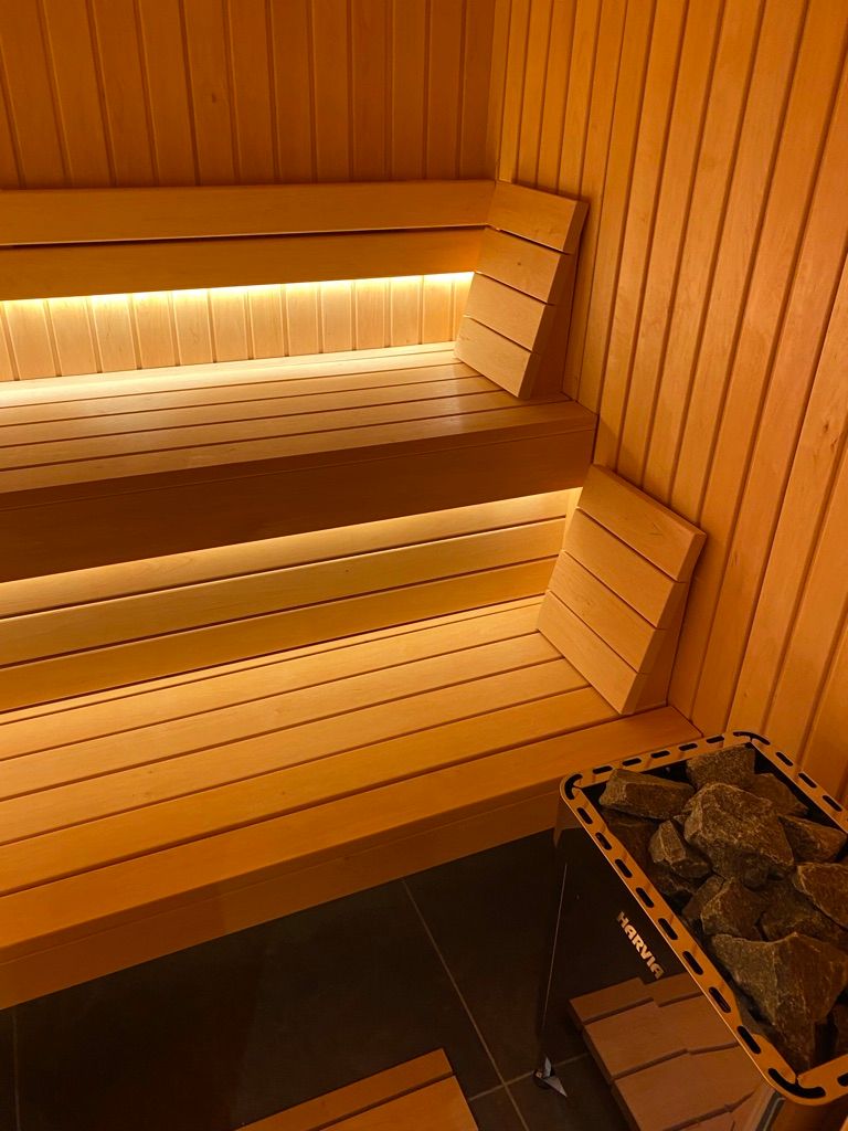 Un sauna en bois avec un banc et un poêle.