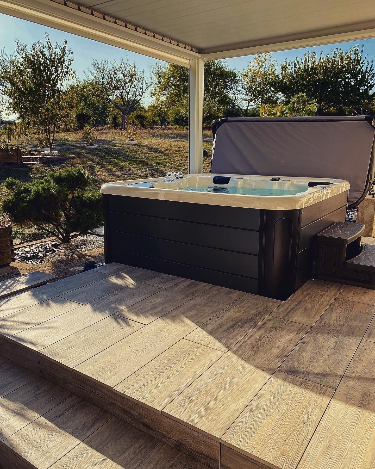 Un bain à remous est installé sous un auvent sur une terrasse.