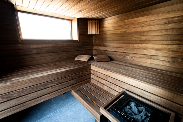 Un sauna en bois avec une fenêtre et un poêle.