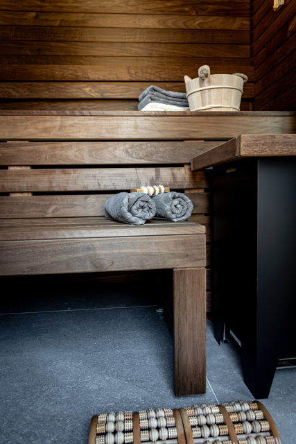 Deux serviettes sont posées sur un banc en bois dans un sauna.
